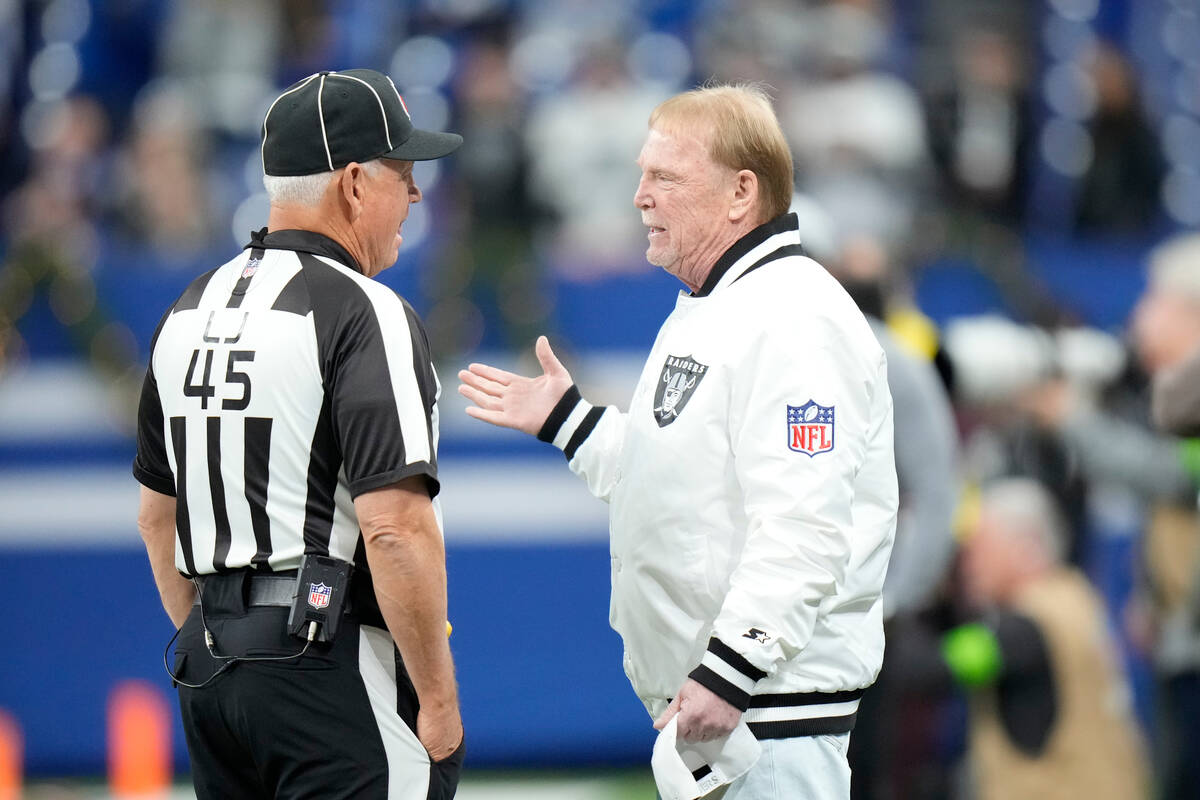 Las Vegas Raiders owner Mark Davis talks to line judge Jeff Seeman (45) before an NFL football ...