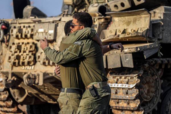 Israeli soldiers embrace after arriving from combat in the Gaza Strip at an army staging area i ...