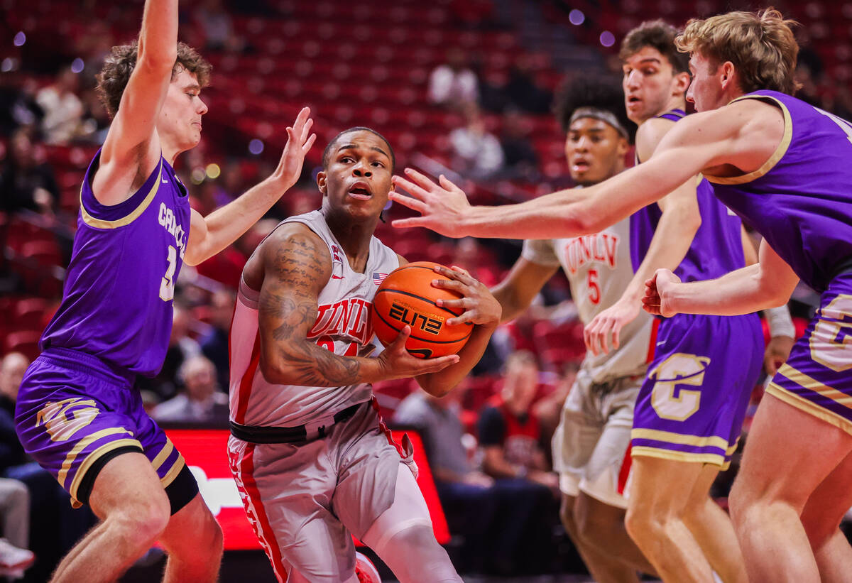 UNLV Rebels guard Jackie Johnson III (24) works his way around Carroll College Fighting Saints ...