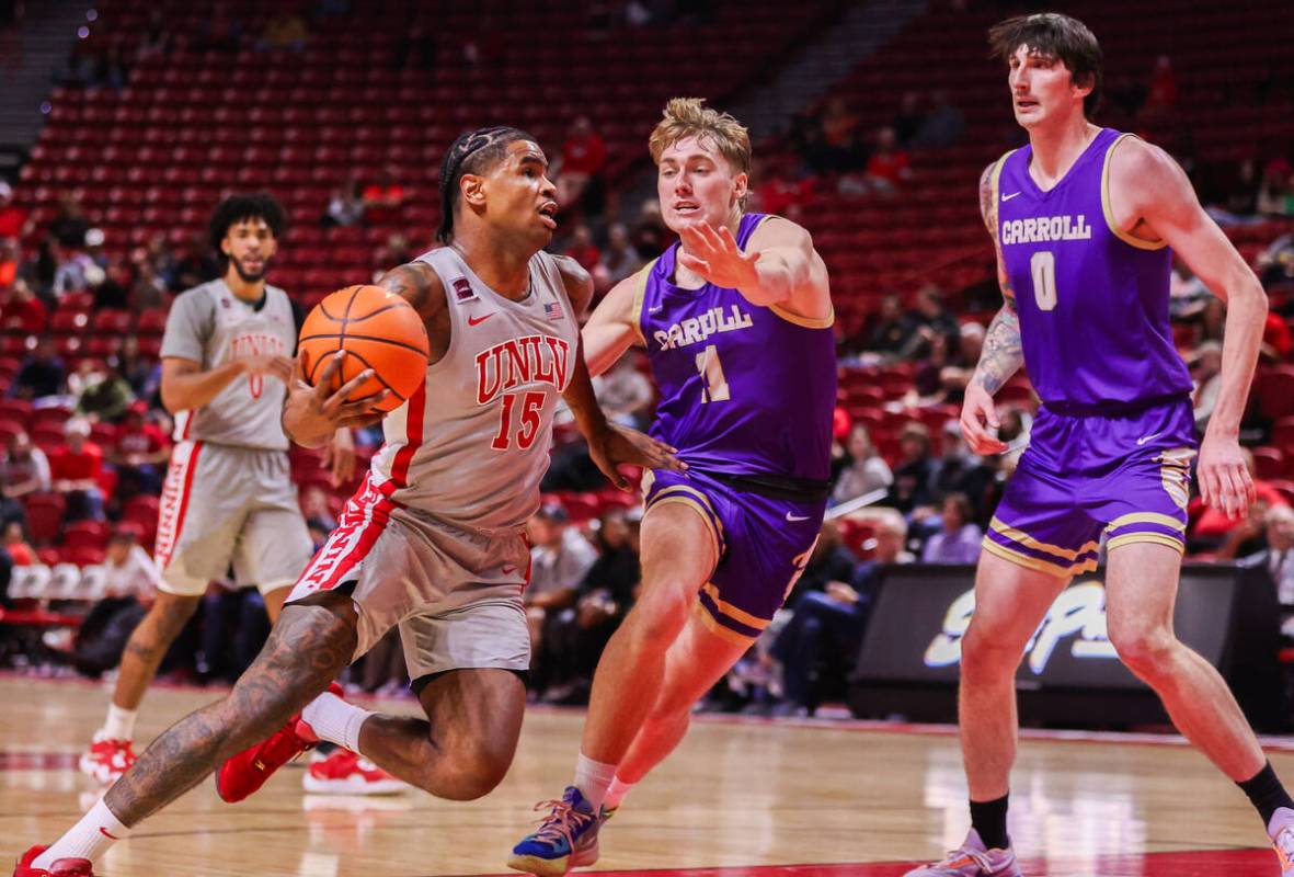 UNLV Rebels guard Luis Rodriguez (15) drives to the basket past Carroll College Fighting Saints ...