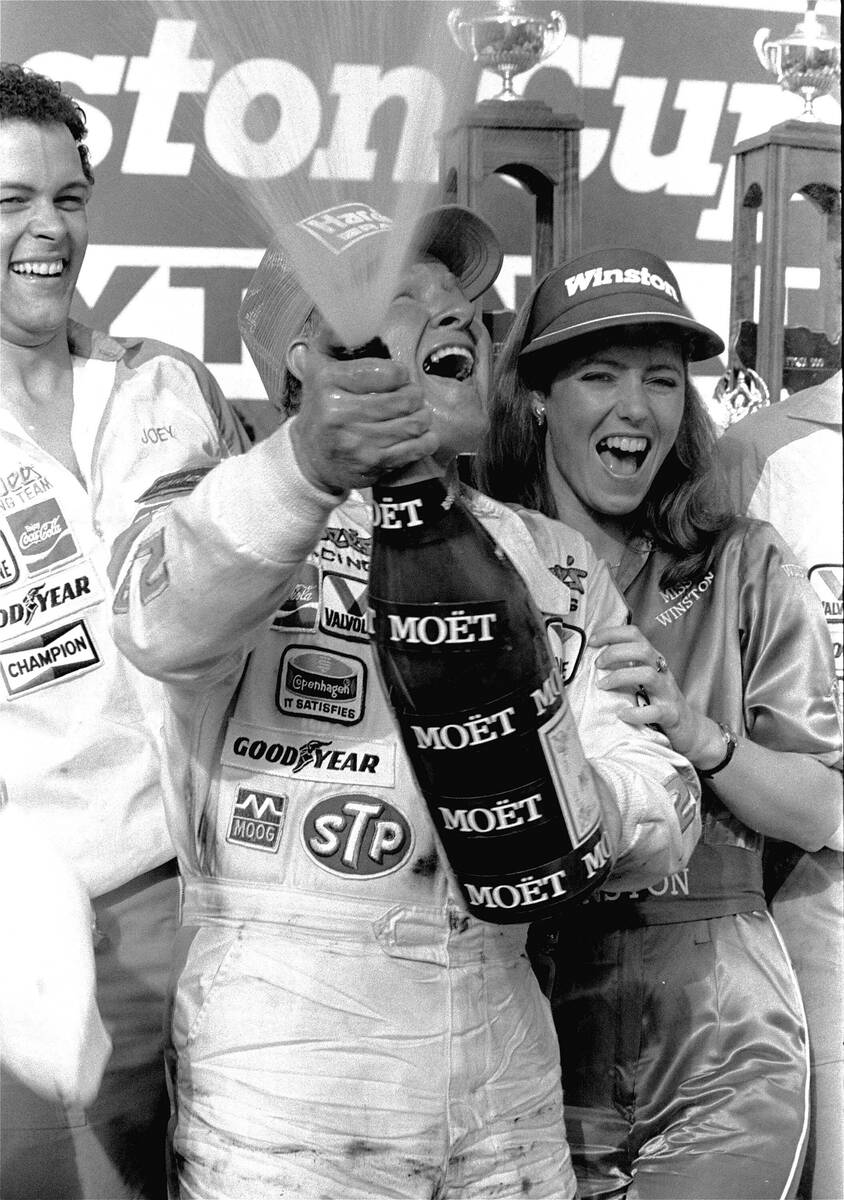 FILE - Cale Yarborough, from Timmonsville, S.C., sets off a Victory Lane shower with a bottle o ...