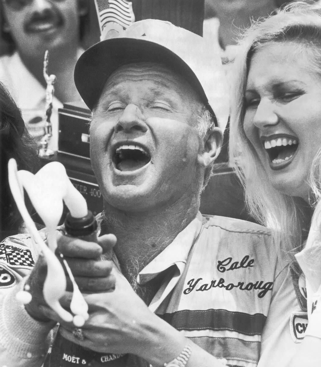 FILE - Cale Yarborough pops a champagne bottle in the winner's circle at Daytona International ...