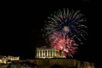 Fireworks explode over the ancient Parthenon temple at the Acropolis hill during New Year's cel ...