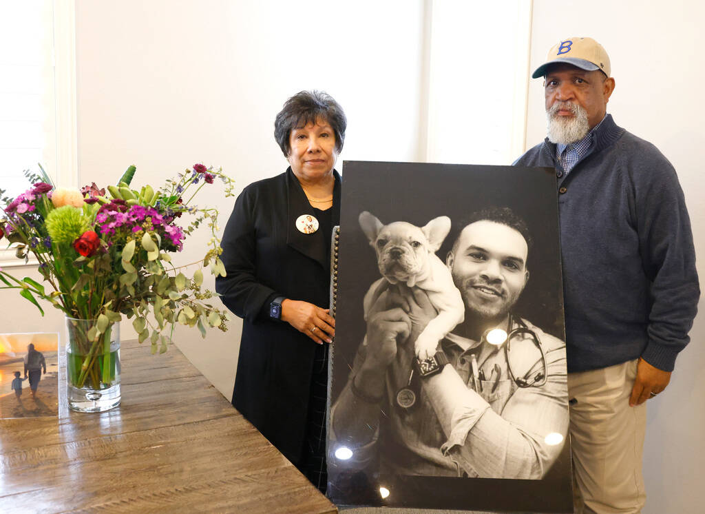 Tonnie Bivens and his wife, Susan Hernandez, pose with a photograph of their son Dr. Aaron Bive ...