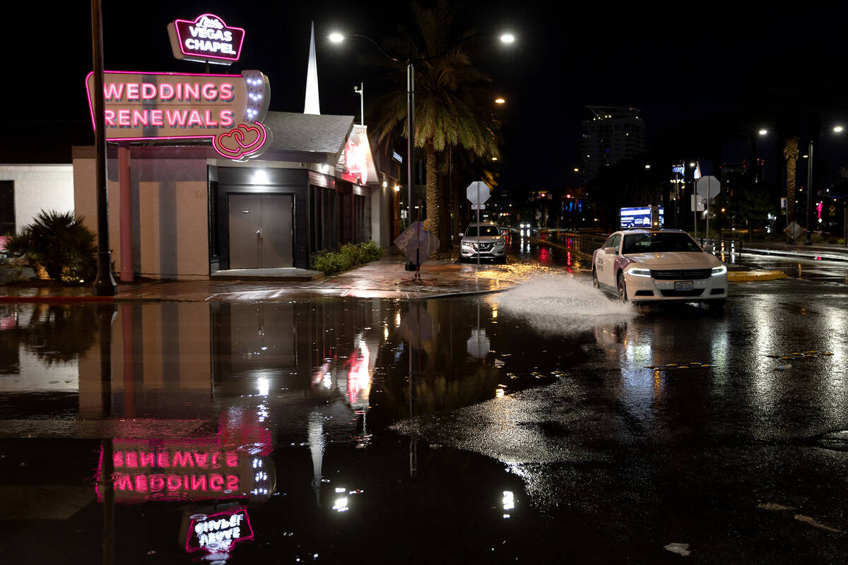 A taxi drives through flash flood waters down South 3rd Street at East Imperial Avenue on Wedne ...