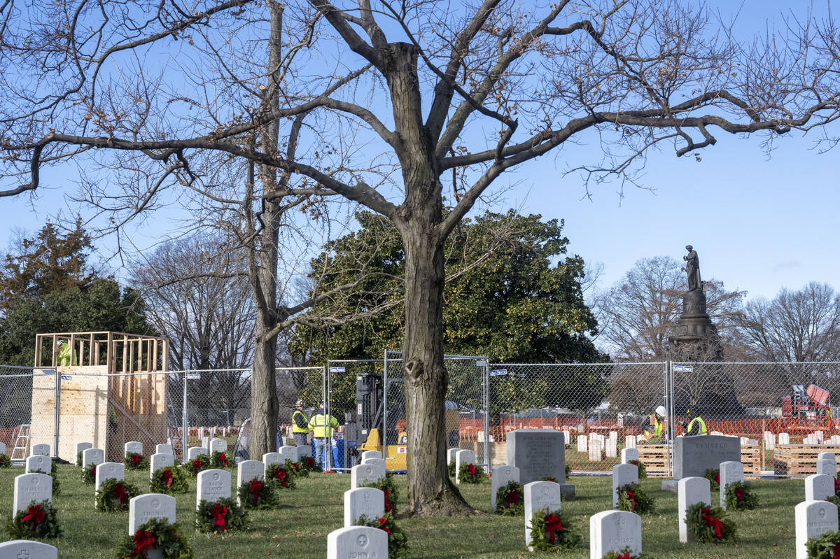 Worker build a crate to hold the statue, left, as they prepare to remove a Confederate Memorial ...