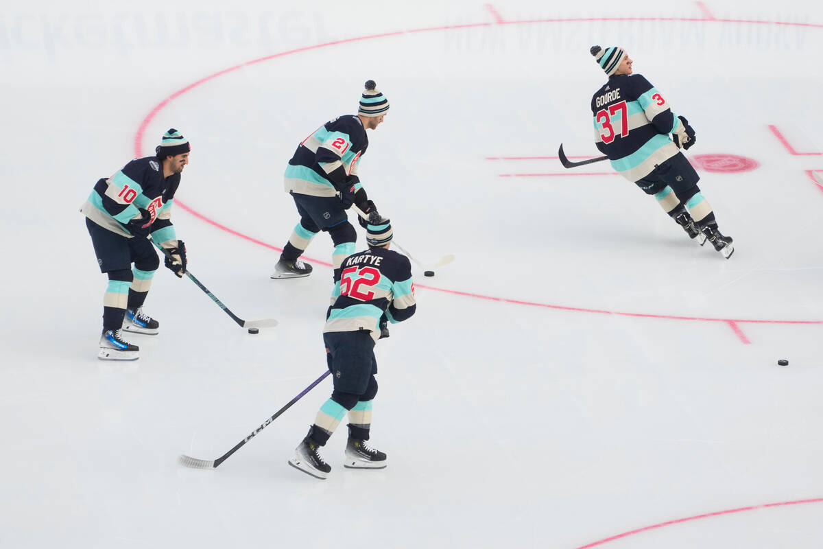 Members of the Seattle Kraken, including center Matty Beniers (10), center Alex Wennberg (21), ...