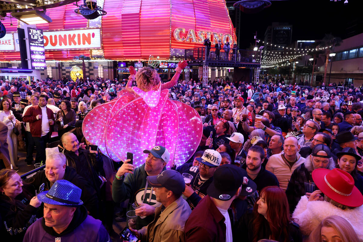 New Year’s Eve revelers watch stilt walker Tida Siribongkot at the 3rd Street Stage dur ...