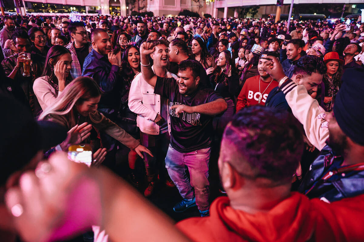 New Year’s revelers dance in the middle of the Strip as midnight nears on Sunday, Dec. 3 ...