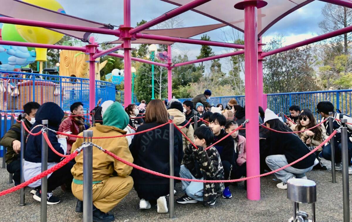 People crouch following an earthquake at Universal Studios Japan in Osaka, western Japan Monday ...