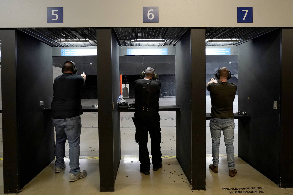 Gun owners fire their pistols at an indoor shooting range during a qualification course to rene ...