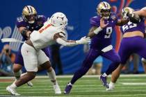 Washington quarterback Michael Penix Jr. (9) scrambles with the ball against Texas defensive en ...