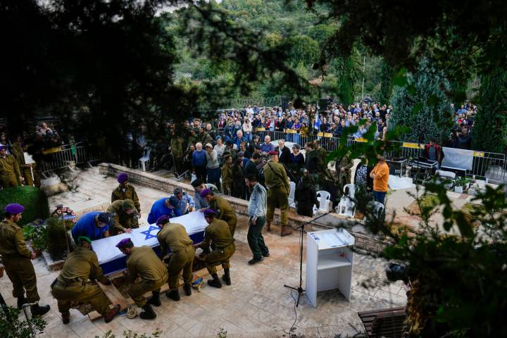 Israeli soldiers lower the coffin of American-Israeli reserve solider Sgt. 1st Class Amichai Yi ...