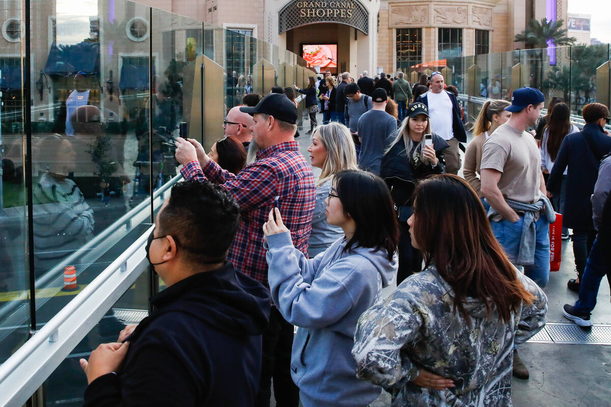 Tourists take pictures along a pedestrian bridge that crosses over Sands Avenue on Tuesday, Jan ...