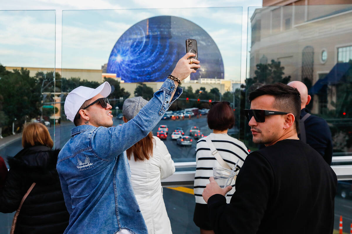 Tourists take pictures along a pedestrian bridge that crosses over Sands Avenue on Tuesday, Jan ...