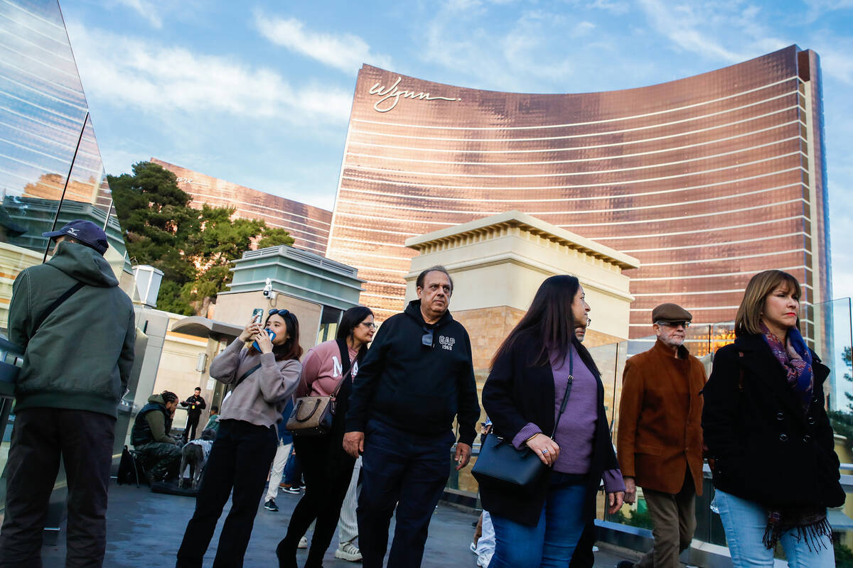 Tourists walk over a pedestrian bridge that crosses over Sands Avenue on Tuesday, Jan. 2, 2024, ...