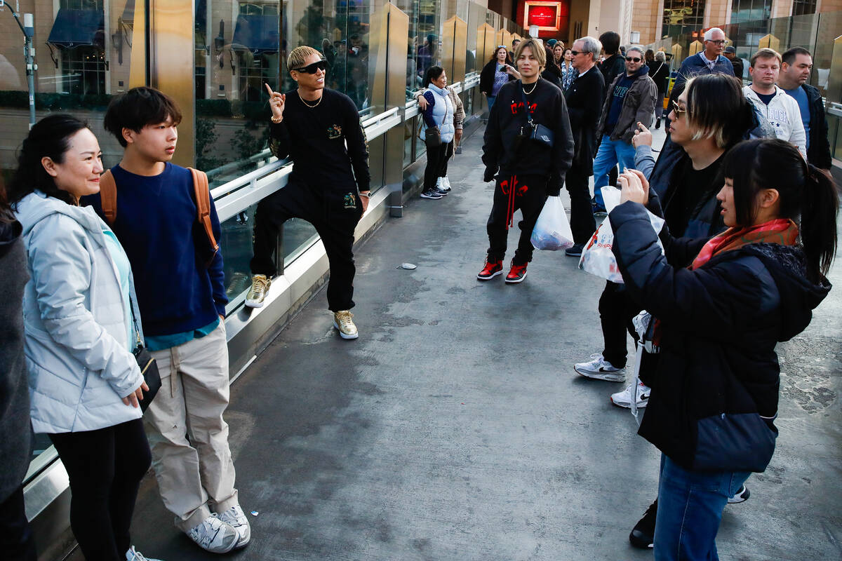 Tourists take pictures along a pedestrian bridge that crosses over Sands Avenue on Tuesday, Jan ...