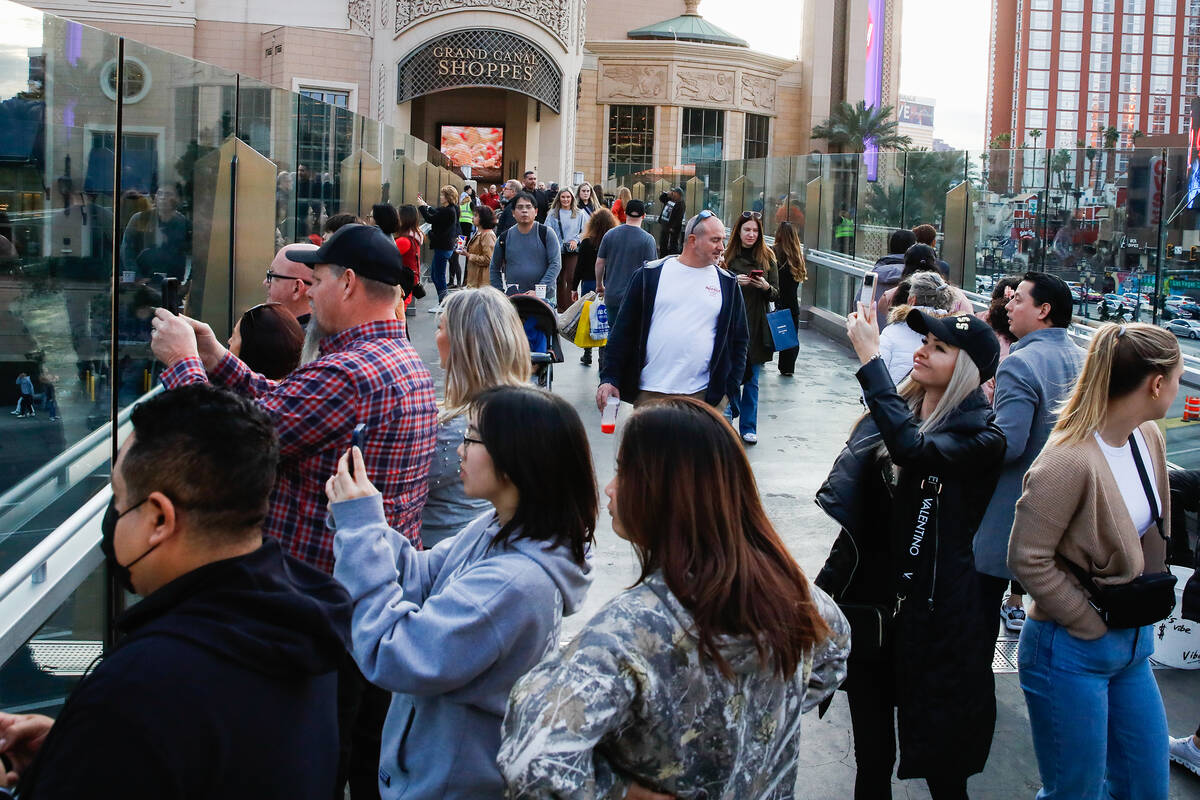 Tourists take pictures along a pedestrian bridge that crosses over Sands Avenue on Tuesday, Jan ...