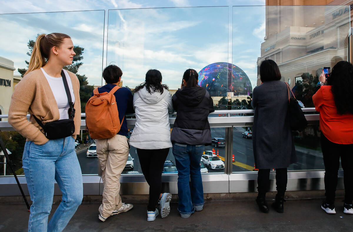 Tourists take pictures along a pedestrian bridge that crosses over Sands Avenue on Tuesday, Jan ...