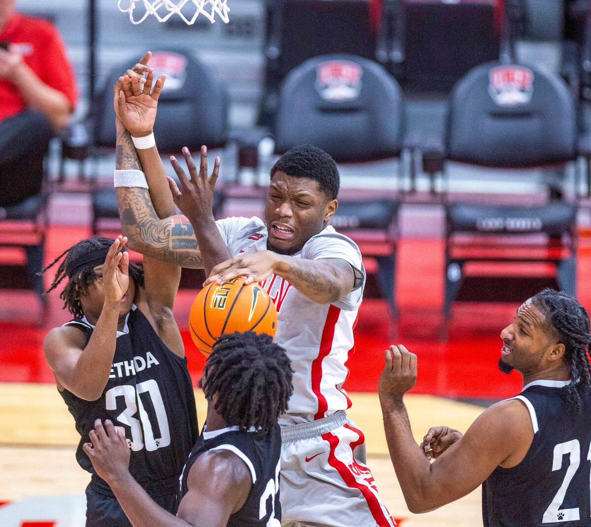 UNLV Rebels forward Karl Jones (22) battles for a rebound with Bethesda University Flames guard ...