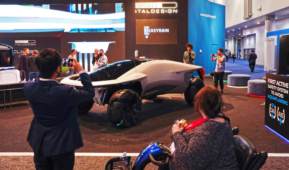 Attendees check out a Delorean concept vehicle at the Italdesign booth during the final day of ...