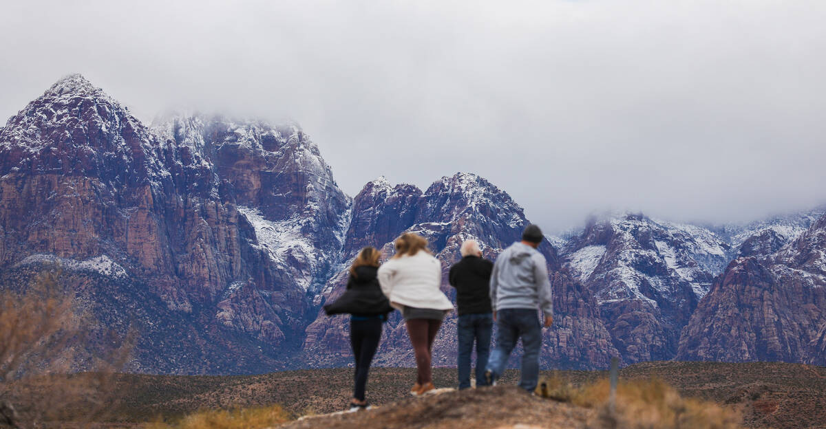 Visitors explore Red Rock Canyon after a dusting of snow blankets the mountains on Wednesday, J ...