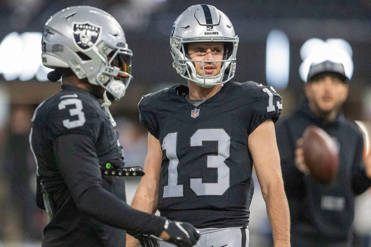 Raiders wide receiver Hunter Renfrow (13) walks past wide receiver DeAndre Carter (3) before an ...