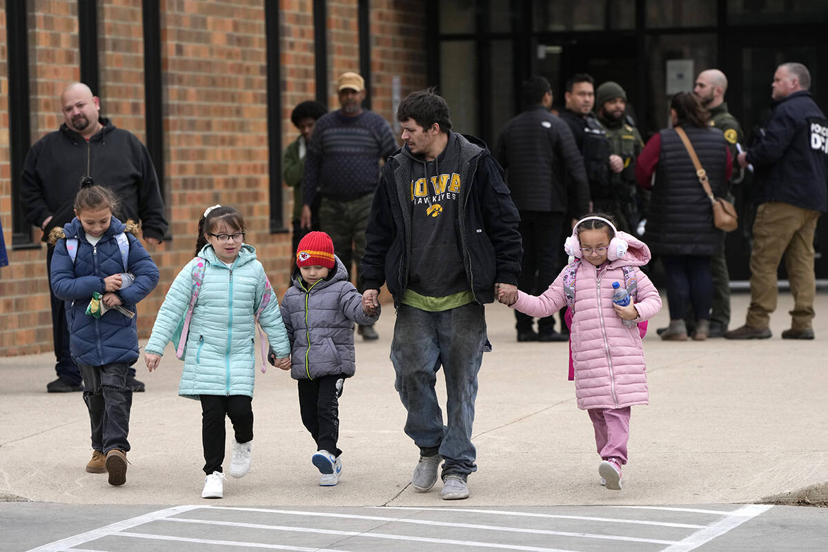 A man and children leave the McCreary Community Building after being reunited following a shoot ...