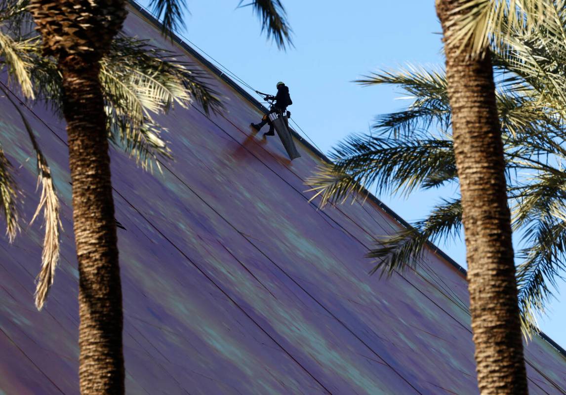 A worker wraps the east side of the Luxor with the Doritos ad, on Thursday, Jan. 4, 2024, in La ...