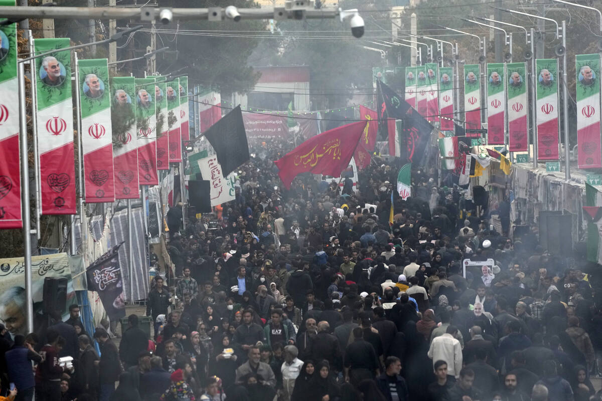 People walk on the street towards the grave of the late Iranian Revolutionary Guard Gen. Qassem ...