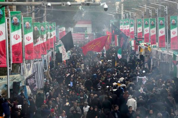 People walk on the street towards the grave of the late Iranian Revolutionary Guard Gen. Qassem ...