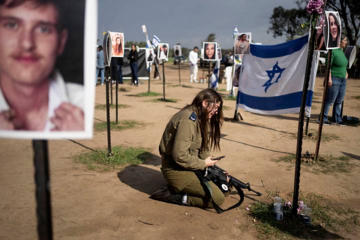 An Israeli soldier weeps at the marker for a loved one kidnapped on Oct. 7 in a cross-border at ...