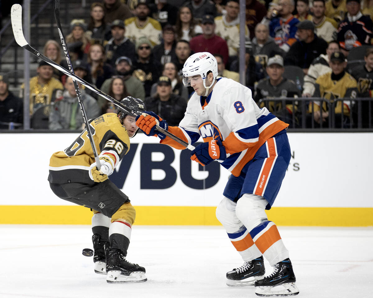 Golden Knights defenseman Tobias Bjornfot (26) loses the puck to Islanders defenseman Noah Dobs ...