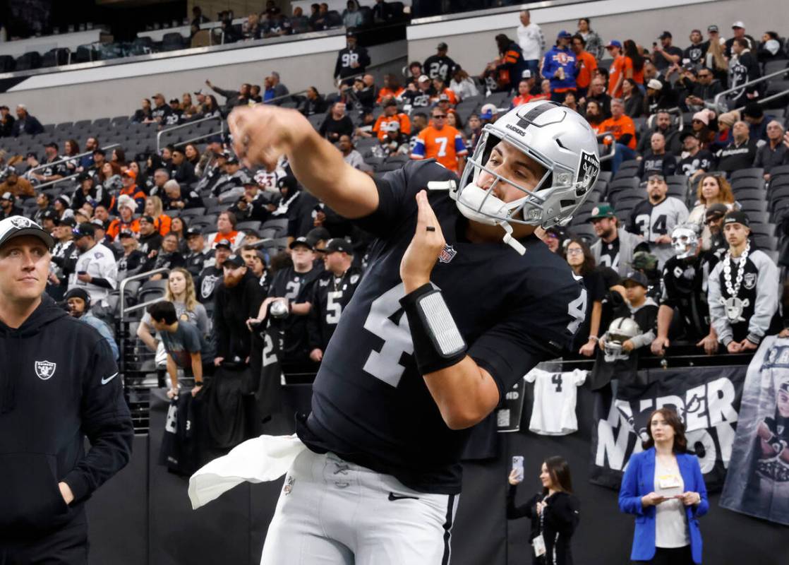 Raiders quarterback Aidan O'Connell (4) watches his throw as he warms up to face the Denver Bro ...