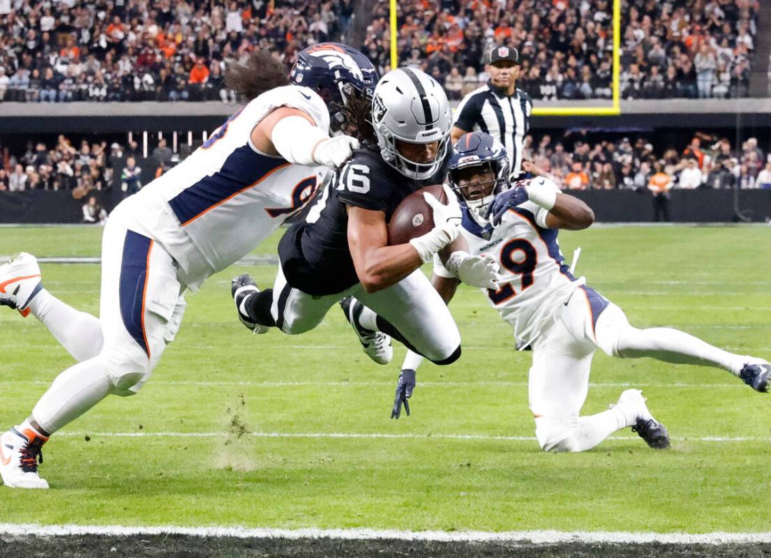 Raiders wide receiver Jakobi Meyers (16) dives for a touchdown asDenver Broncos defensive tackl ...