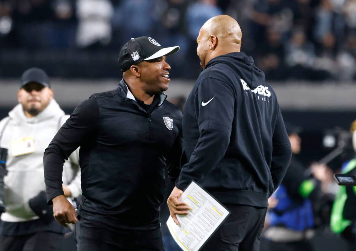 Raiders Interim Coach Antonio Pierce, right, and General Manager Champ Kelly celebrate after th ...