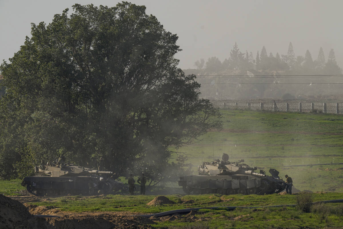 Israeli soldiers are seen near the Gaza Strip border, in southern Israel, Sunday, Jan.7, 2024. ...