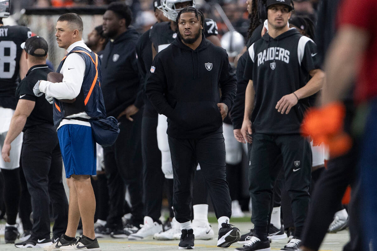 Raiders running back Josh Jacobs watches the team play from the sideline during the first half ...