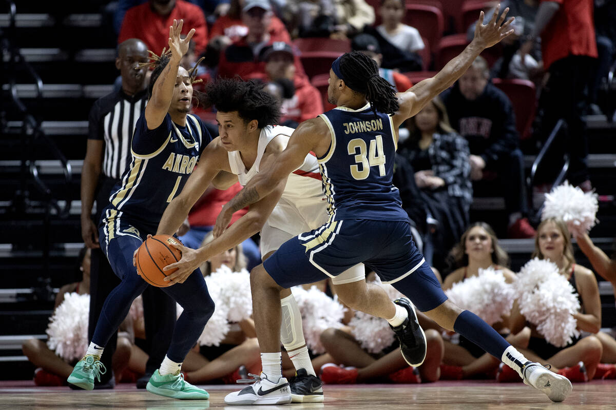 UNLV Rebels forward Jalen Hill (1) drives between Akron Zips guard Shammah Scott (1) and guard ...