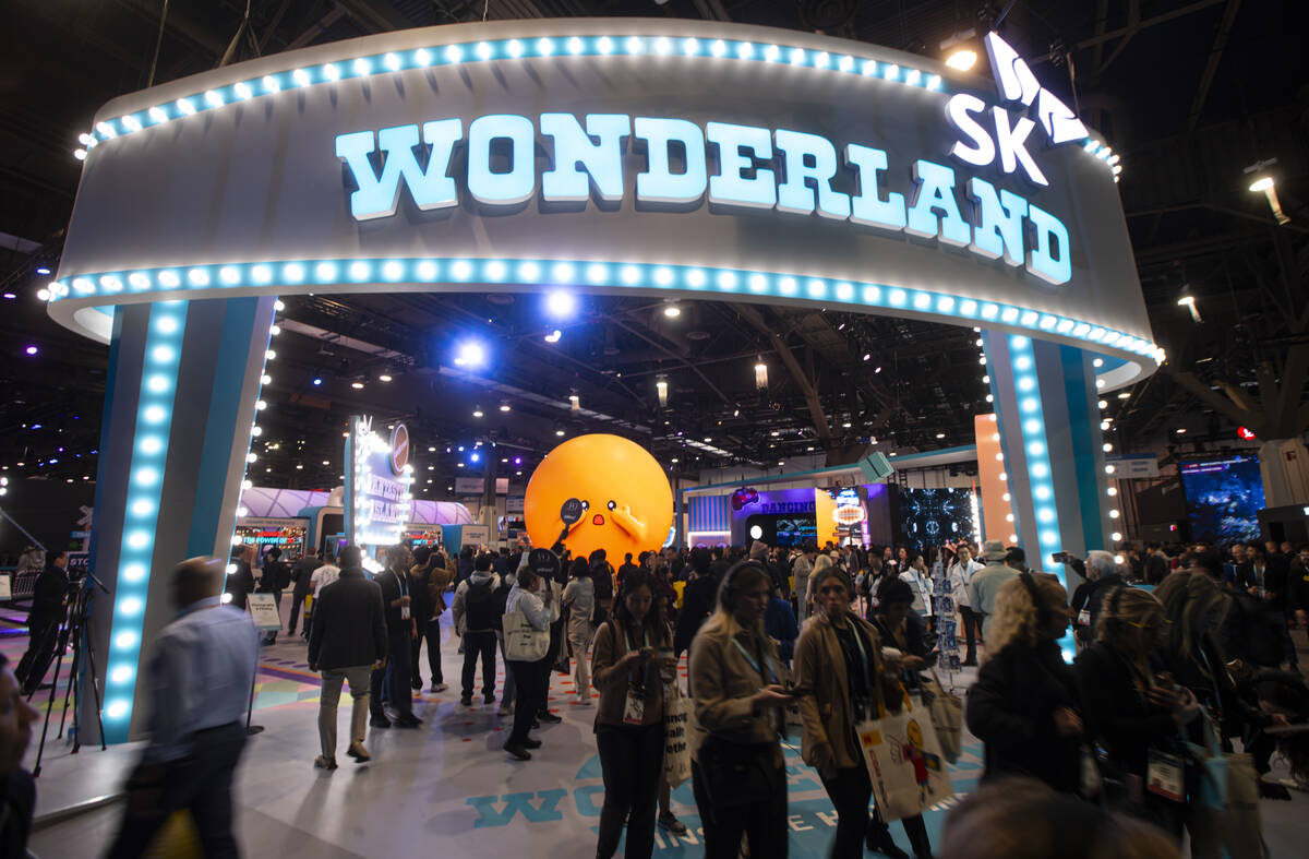 Attendees come and go from the SK Group booth during the first day of CES at the Las Vegas Conv ...