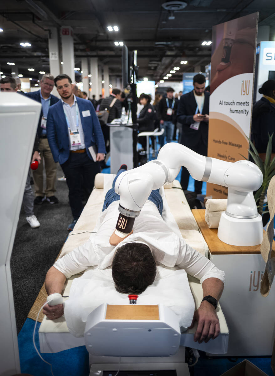 An attendee gets a massage from massage robot iYU during the first day of CES at The Venetian E ...