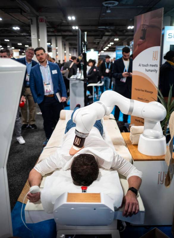 An attendee gets a massage from massage robot iYU during the first day of CES at The Venetian E ...