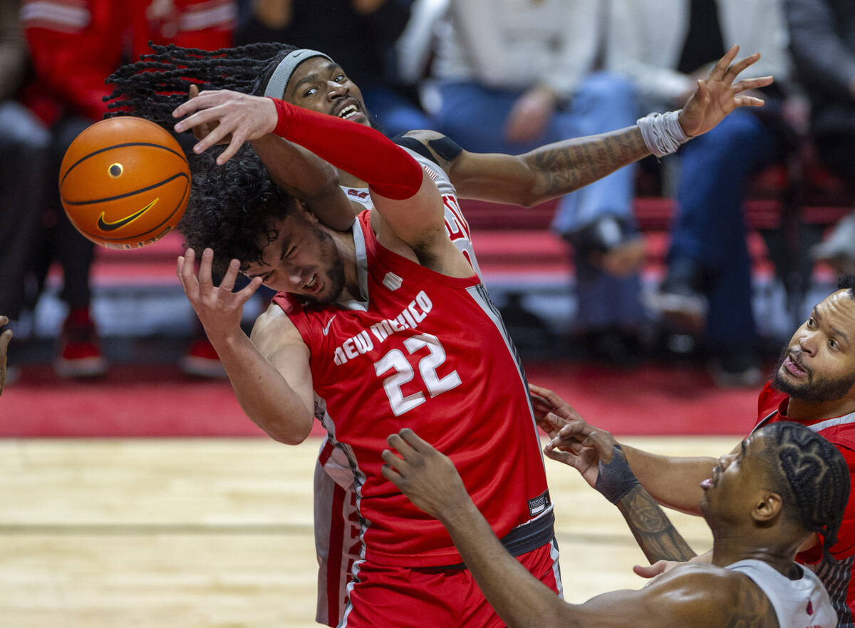 UNLV forward Keylan Boone (20) battles for a loose ball with New Mexico Lobos forward Mustapha ...