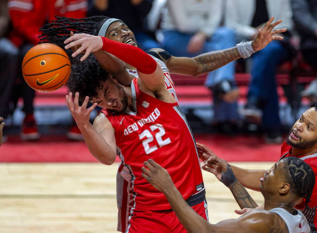 UNLV forward Keylan Boone (20) battles for a loose ball with New Mexico Lobos forward Mustapha ...