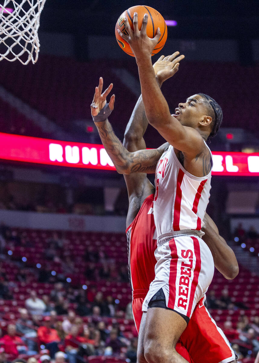 UNLV forward Rob Whaley Jr. (5) gets around New Mexico Lobos center Nelly Junior Joseph (23) fo ...