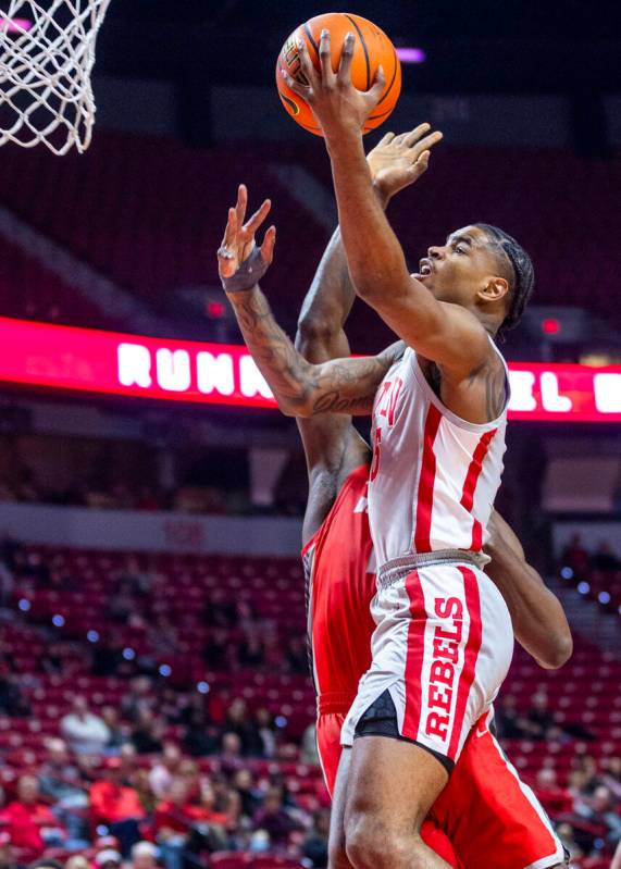 UNLV forward Rob Whaley Jr. (5) gets around New Mexico Lobos center Nelly Junior Joseph (23) fo ...