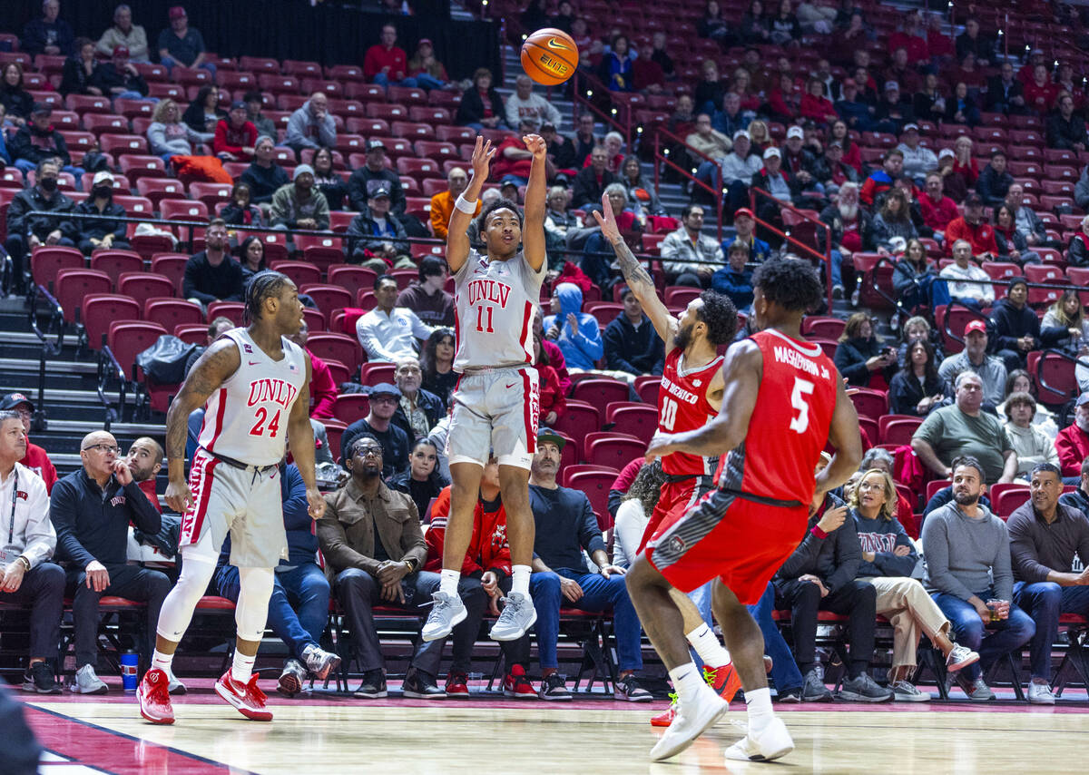 UNLV guard Dedan Thomas Jr. (11) gets off a 3-point basket attempt over New Mexico Lobos guard ...