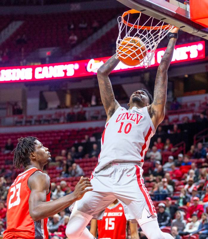 UNLV forward Kalib Boone (10) dunks the ball over New Mexico Lobos center Nelly Junior Joseph ( ...