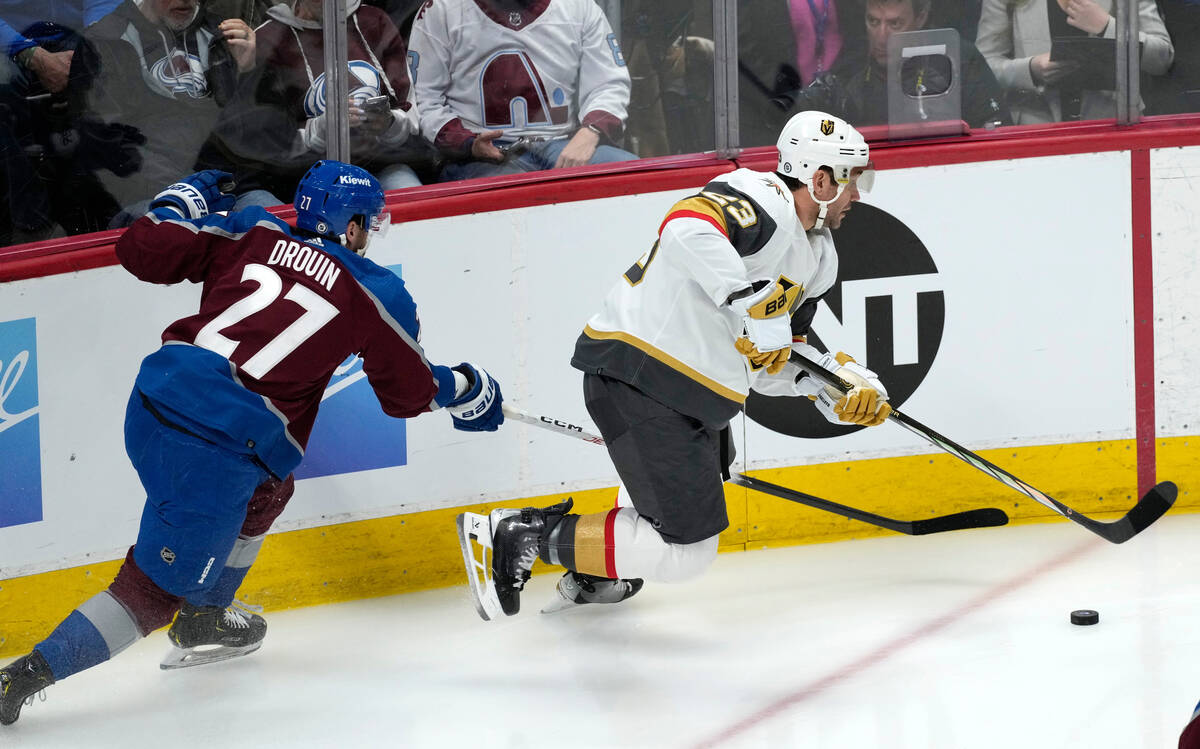 Vegas Golden Knights defenseman Alec Martinez, right, collects the puck as Colorado Avalanche l ...