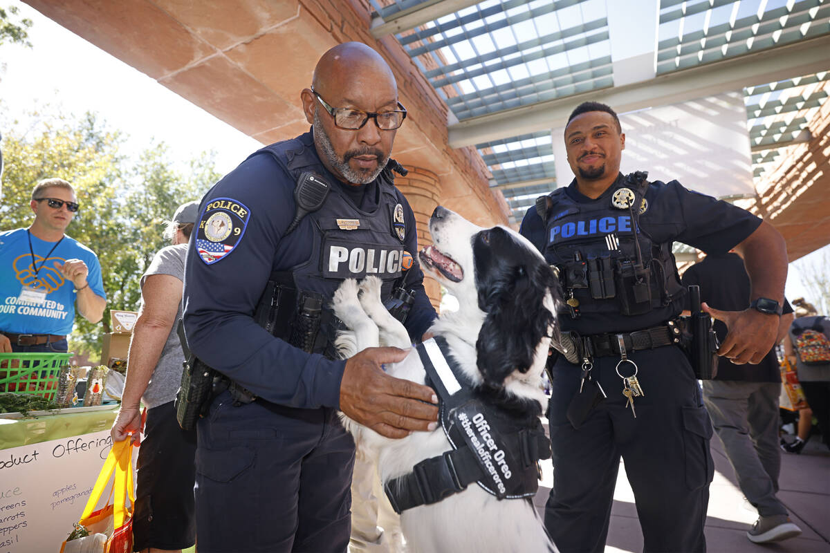 Clark County School District Police Department K-9 officer Anthony Cooke, left, plays with his ...